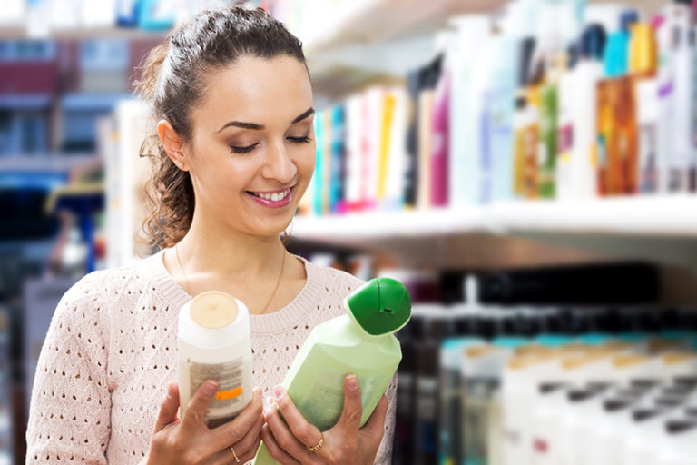 Woman holding a bottle of shampoo and conditioner